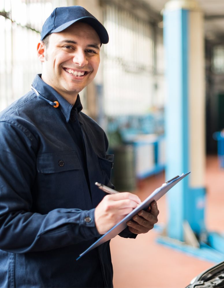 Happy technician ticking off a service sheet - Wheel Alignment, Servicing, Diagnostics Larbert