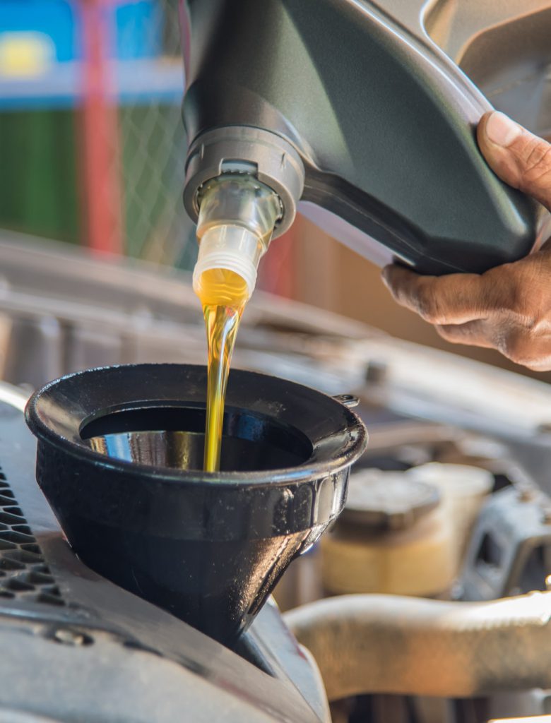 Mechanic pouring engine oil into a vehicle - Car Servicing Larbert